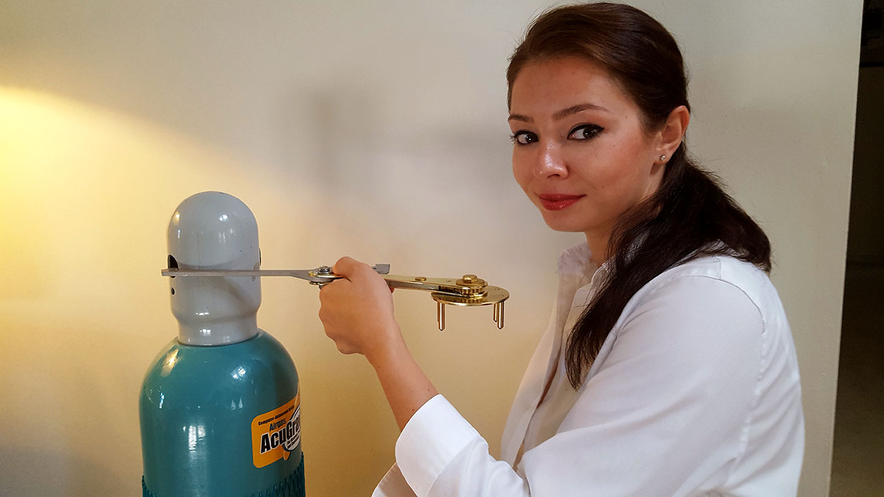 Asian woman with almond eyes, wearing eyeliner, makeup and a white button-up blouse using Multi-Purpose Wrench.